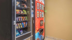 Una máquina expendedora con aperitivos y botellas de Coca-Cola.