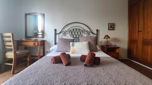A neatly made bed with a patterned bedspread, a wooden desk with a chair, a nightstand with a lamp, and a wardrobe. - La Chalana, two bedroom apartment in El Charco de San Ginés (Arrecife)