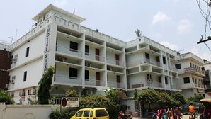 A multi-story building with balconies, a sign for Hotel Sujata, and a parked yellow car. - Hotel Sujata (Gaya)
