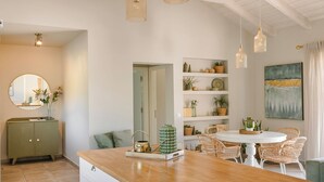Une cuisine moderne avec un plan de travail en bois, des chaises en osier et une table de salle à manger ronde.