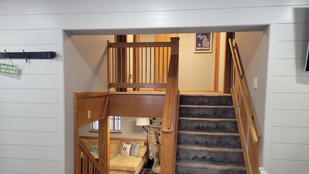 A wooden staircase leading to a loft bedroom with a view of the living room below. - Walking distance to four-season ski and golf resort Crystal Mountain (Thompsonville)