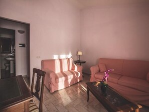 A living room with two sofas, a coffee table, and a lamp. - Al Poggio dei Papi (Citta della Pieve)
