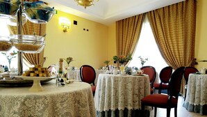A dining area with round tables covered in lace tablecloths, red upholstered chairs, and a chandelier. - Hotel D Apos Angelo Palace (Mazara del Vallo)