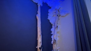 A room with a ceiling that has a blue light effect, two wooden branches, and a radiator. - Studio Nature Avec vue sur le Château (Caen)