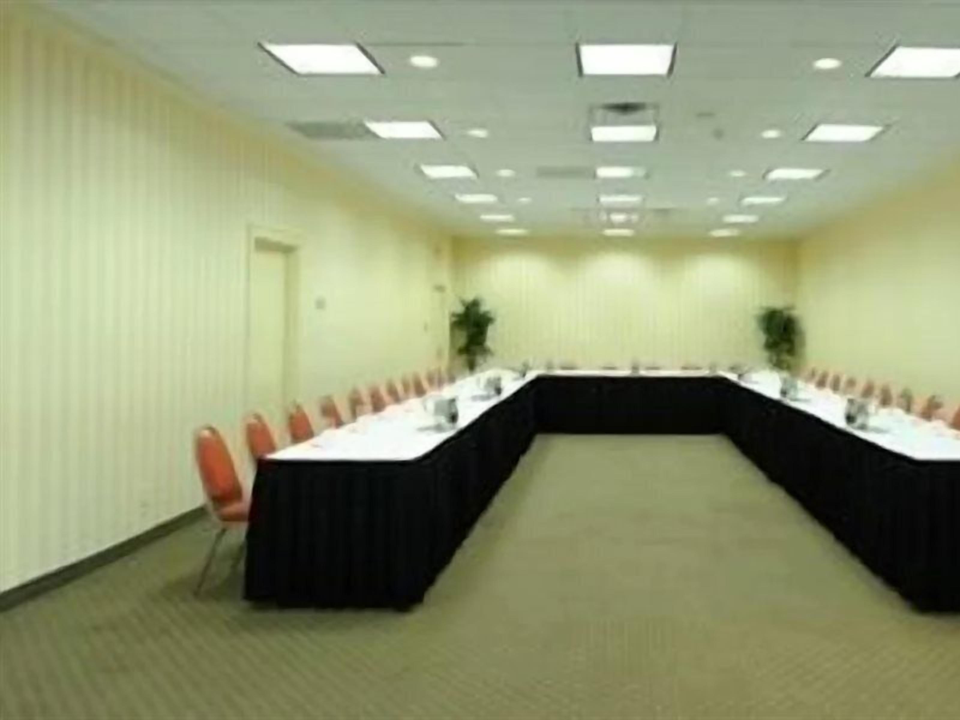 A conference room with a long table, chairs, and a door.
