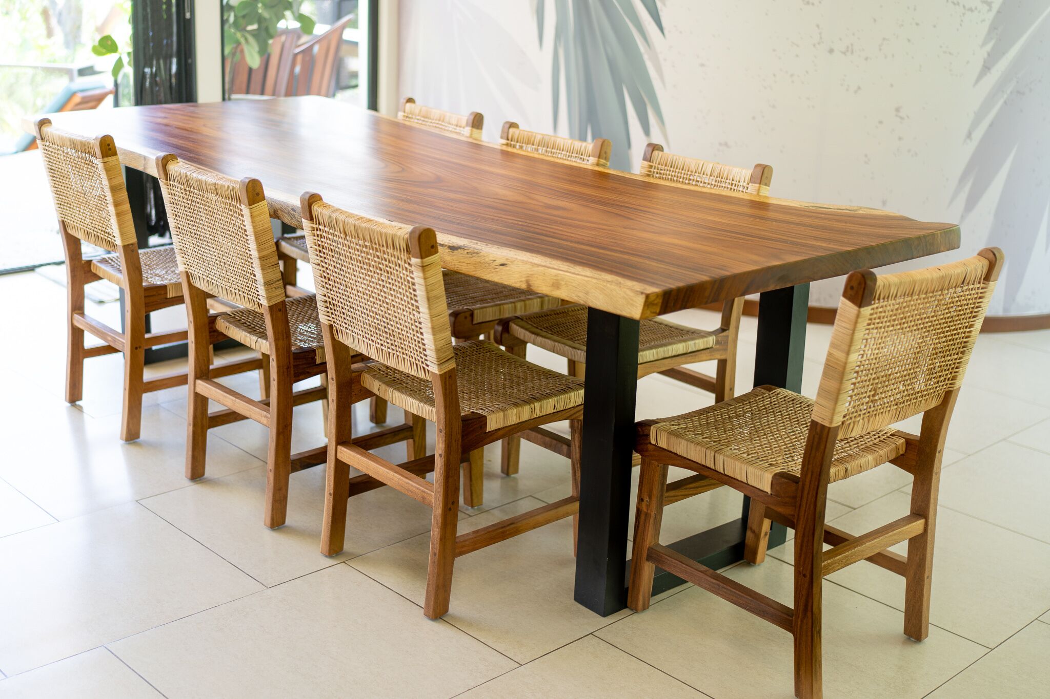 A rectangular wooden dining table with six woven chairs.
