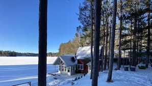 A cabin in a snowy forest with a clear view of a lake. - Near Munising snowmobile trails. Ride out from the property  (Munising)