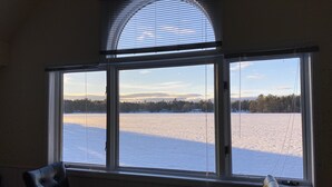 A room with a large window overlooking a snowy landscape. - Near Munising snowmobile trails. Ride out from the property  (Munising)