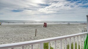 A beach with a lifeguard tower, a sandy shore, and a clear sky. - Daytona Beach Condo w/ Ocean-View Balcony! (Daytona Beach)