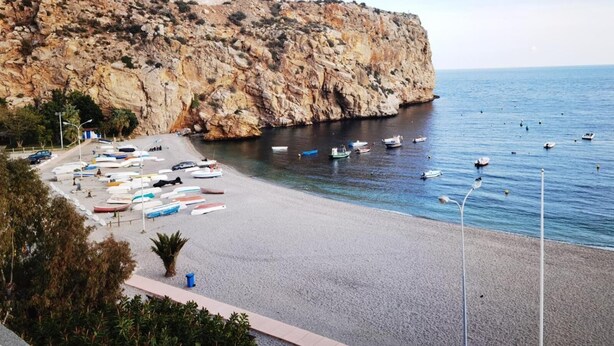 A rocky cliff with a beach in the foreground. - Hotel Embarcadero De Calahonda (Motril)