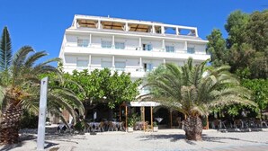 A hotel with a white facade, multiple balconies, and a covered outdoor seating area with palm trees. - Hotel Embarcadero De Calahonda (Motril)