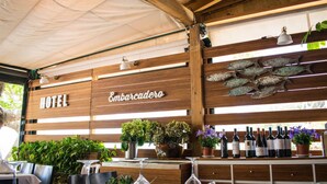 A restaurant with wooden walls, a sign reading "HOTEL Embarcadero", and wine bottles displayed on a shelf. - Hotel Embarcadero De Calahonda (Motril)