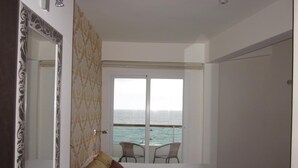 A hotel room with a bed, a chair, and a view of the sea through a large window. - Hotel Embarcadero De Calahonda (Motril)