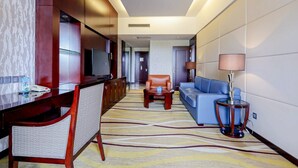 A hotel room with a wooden desk, a television, a sofa, and a lamp. - Hengshan Beijiao Hotel (Shanghai)