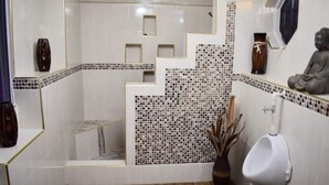 A modern bathroom with a white and black tiled design, a urinal, and decorative vases. - Organic Farm with Majestic Sea & Mountain View Wing 2 (2 Bedrooms, 2 Bathrooms) (Bluefields)