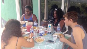 A group of people dining at an outdoor table with a view of the mountains. - Organic Farm with Majestic Sea & Mountain View Wing 2 (2 Bedrooms, 2 Bathrooms) (Bluefields)