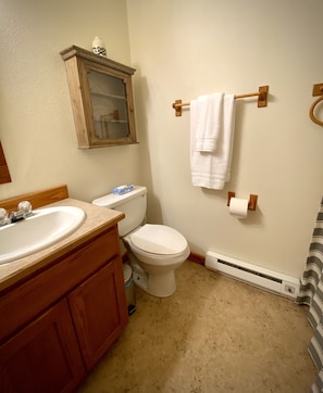 A bathroom with a wooden vanity, a toilet, a towel rack, and a mirror. - Park Place (Darby)