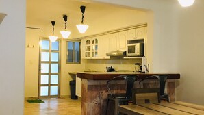 A modern kitchen with white cabinets, a central island, and pendant lighting.