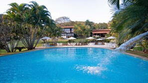 Una piscina al aire libre, sombrillas, tumbonas
