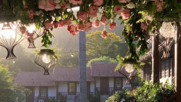 A table set for a meal with a view of traditional houses and a garden. - Estalagem Alter Real (Pirenópolis)