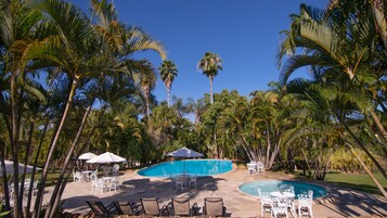 Una piscina al aire libre, sombrillas, tumbonas