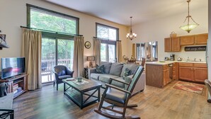 A spacious living room with a sofa, a rocking chair, a coffee table, and a television. - Your Windham Fall and Winter Escape Awaits! (Windham)