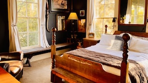 A bedroom with a wooden bed, large windows, a desk, and a chair. - Historic 1906, 15 acre Ranch with pool 20 minutes from SeaWorld (San Antonio)
