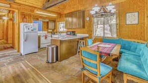 L’intérieur d’un chalet en bois comprend une cuisine, un coin repas et un espace salon confortable.