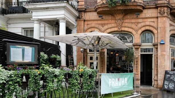 Un restaurante con un cartel verde que dice 'PRAVHA' y un letrero que indica 'DRAYTON GARDENS, S.W.10'.