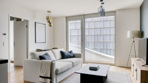 Ein modernes Wohnzimmer mit Sofa, Couchtisch und großem Fenster mit Blick.