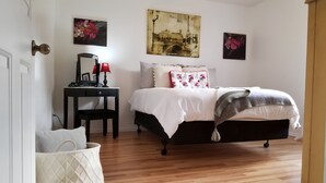 Une chambre à coucher avec un lit, une table de chevet, une lampe et des œuvres d’art murales.