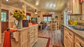 L’intérieur d’un chalet en bois comprend une cuisine, un coin repas et un salon.