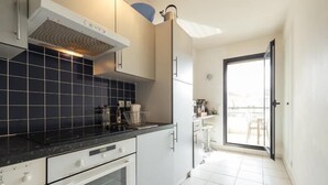 Eine moderne Küche mit weißen Schränken, einer schwarzen Küchenrückwand und einem eingebauten Backofen.