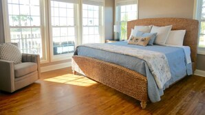 A bedroom with a large bed, a ceiling fan, and a view through large windows. - Dates Available!!  Check out our property!! (Port St Joe)