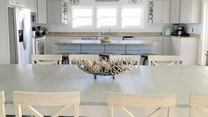 A spacious kitchen with white cabinets, a large island with a decorative bowl, and pendant lights. - Dates Available!!  Check out our property!! (Port St Joe)