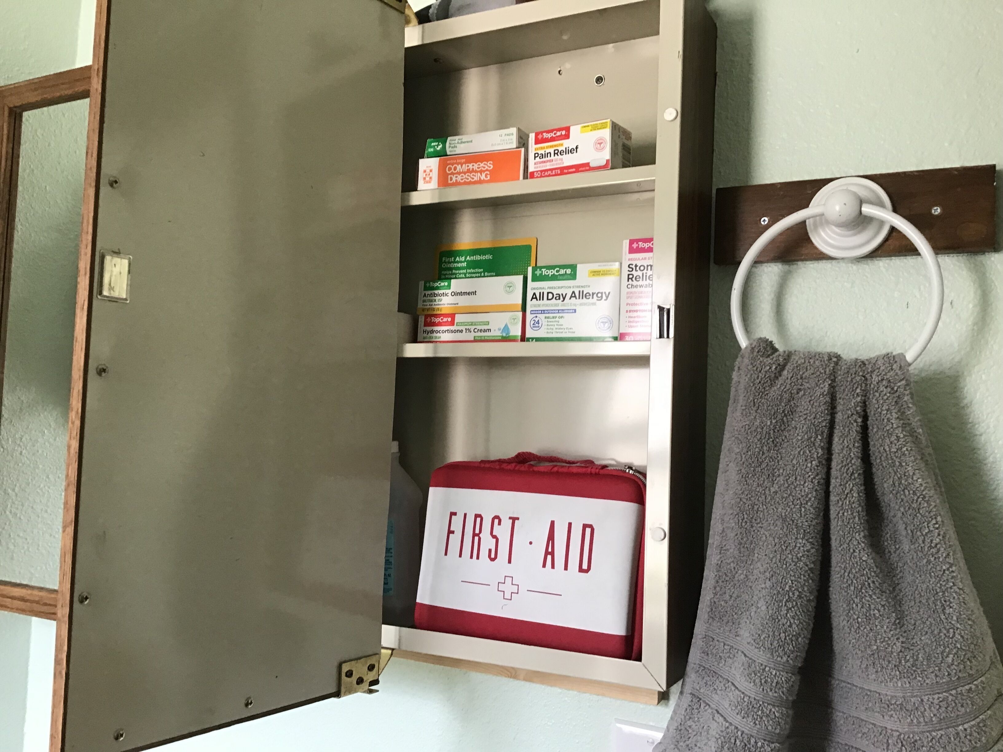 Un botiquín de primeros auxilios en un armario con diversos artículos relacionados con la salud en los estantes.