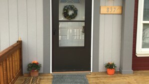 A front door with a wreath, a mailbox, and a house number sign. - Bright and cheerful. With glorious sunrise/sunset views, close to Glacier park. (Columbia Falls)