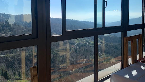 Una habitación con amplios ventanales que ofrecen vistas a un paisaje montañoso.