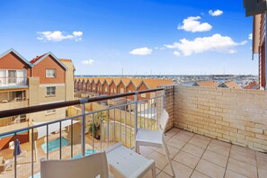 A balcony with a view of a marina and a swimming pool. - Nautica Residences Hillarys (Hillarys)