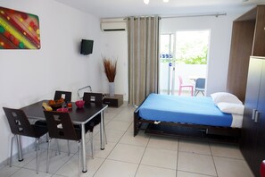 A room with a bed, a dining table with chairs, a TV, and a window with curtains. - Residence le Saint Esteve (La Ciotat)