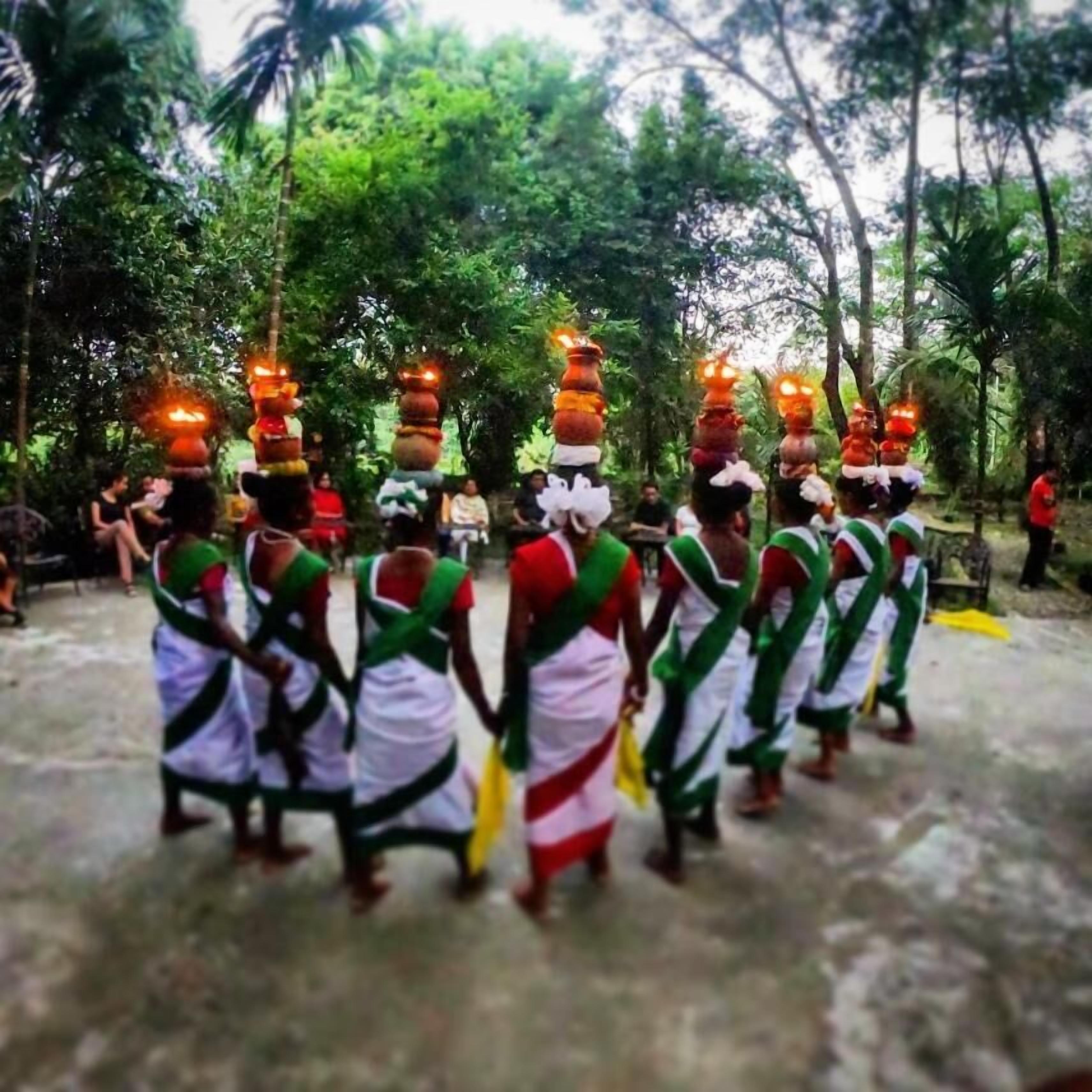 A group of people in traditional attire performing a ritual with decorated items.