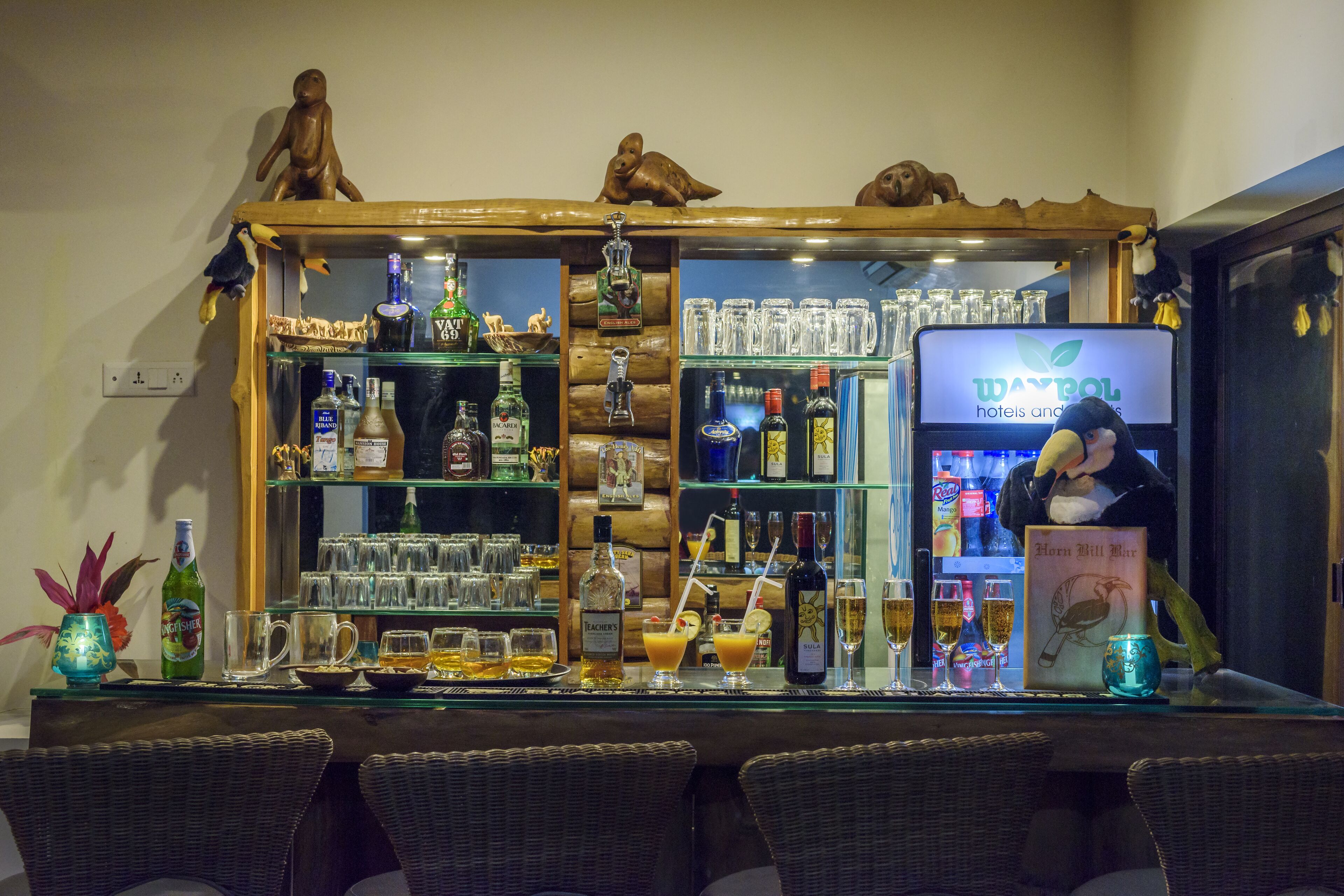 A bar area with a variety of liquor bottles, glasses, and a sign for Waybol hotels.