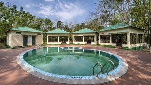 A swimming pool with a depth of 4.5 meters, surrounded by three small buildings with green roofs. - The Riverwood Forest Retreat - Dooars (Mal)