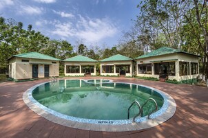 A swimming pool with a depth of 4.5 meters, surrounded by three small buildings with green roofs.