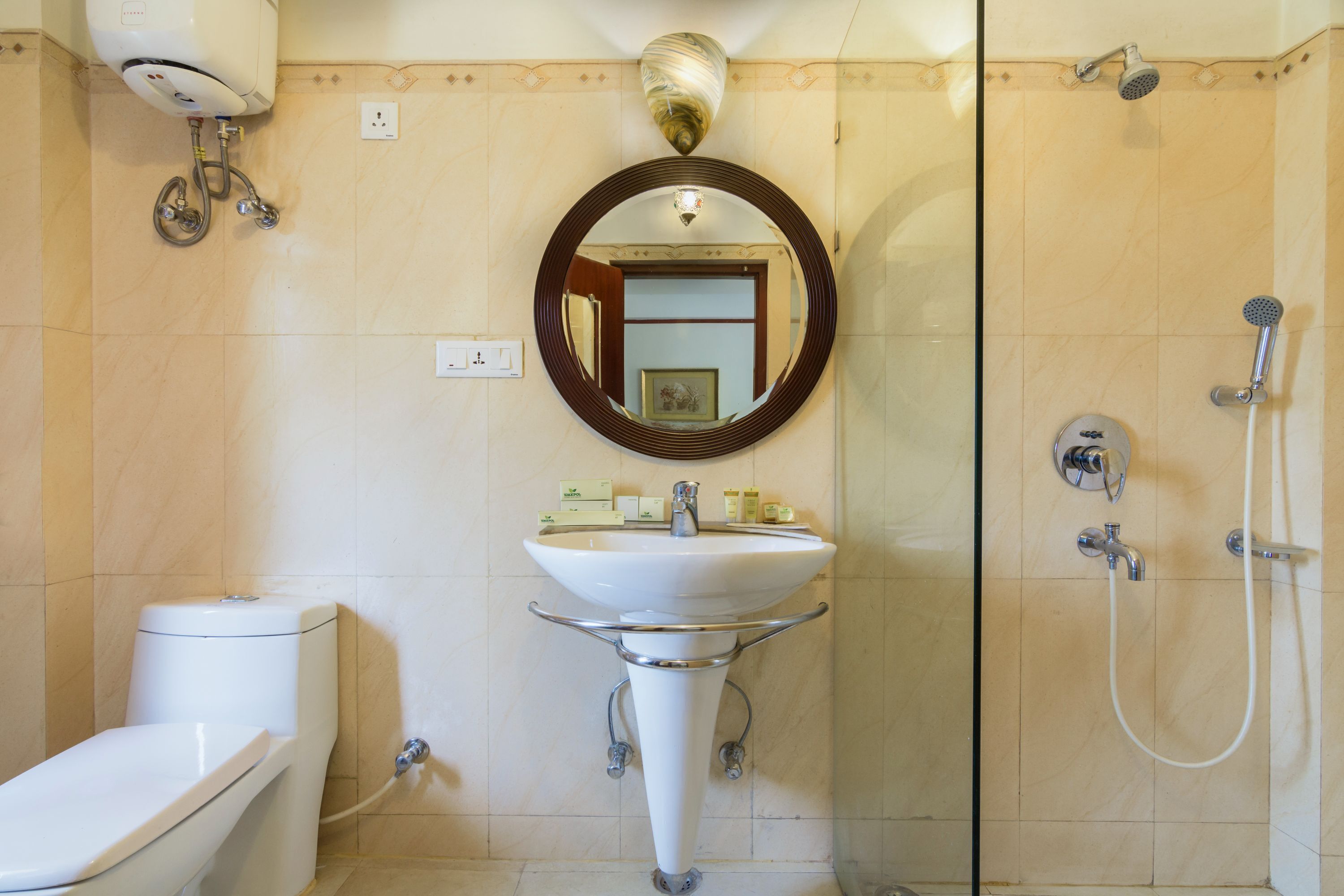 A bathroom with a toilet, sink, and shower.