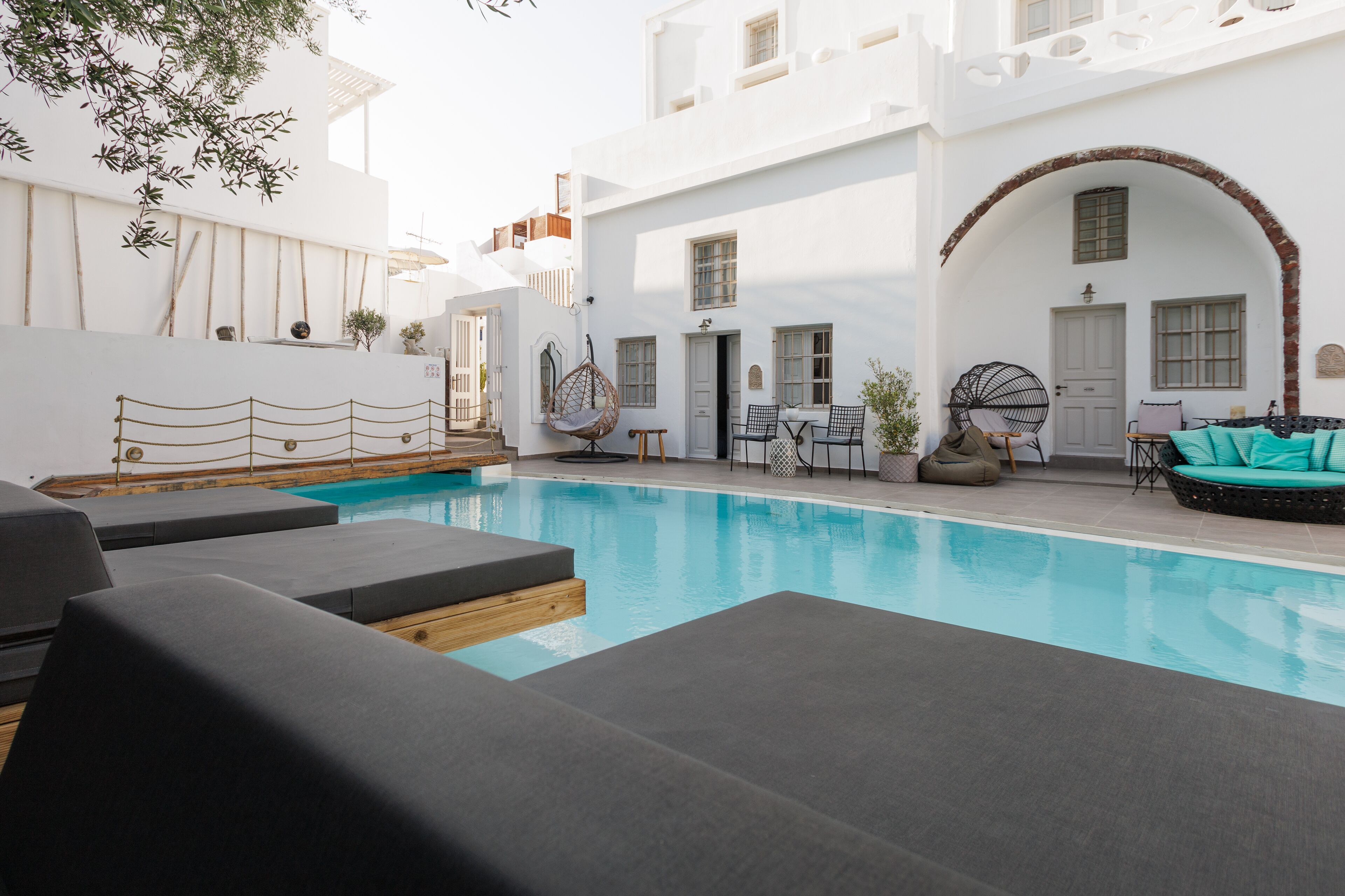 Ein Poolbereich mit Liegestühlen und einer Sitzecke mit Tisch und Stühlen.