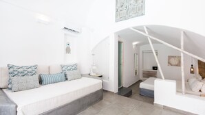Une chambre moderne avec un lit, un fauteuil suspendu et un escalier menant à une autre pièce.