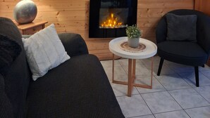 Ein gemütliches Wohnzimmer mit Kamin, einem großen Hirschgemälde und einer modernen Lampe.