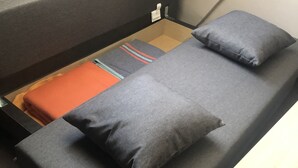 Une petite pièce, de taille modeste, comprenant un lit simple, une petite table et une fenêtre.
