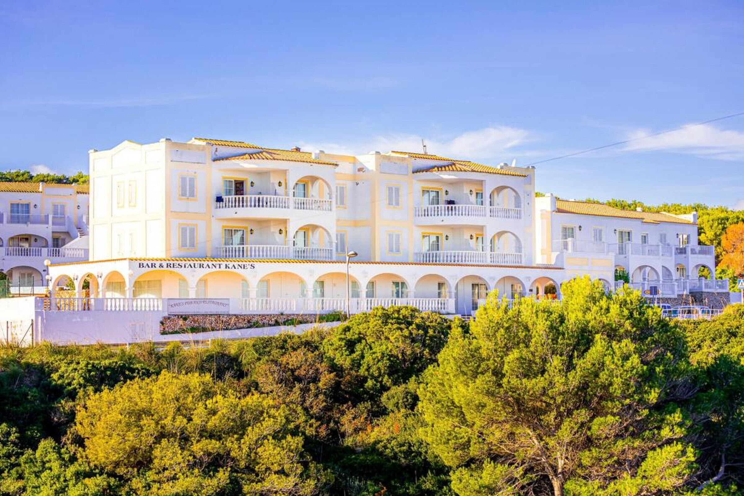 A multi-story hotel with balconies and a bar & restaurant on the ground floor.